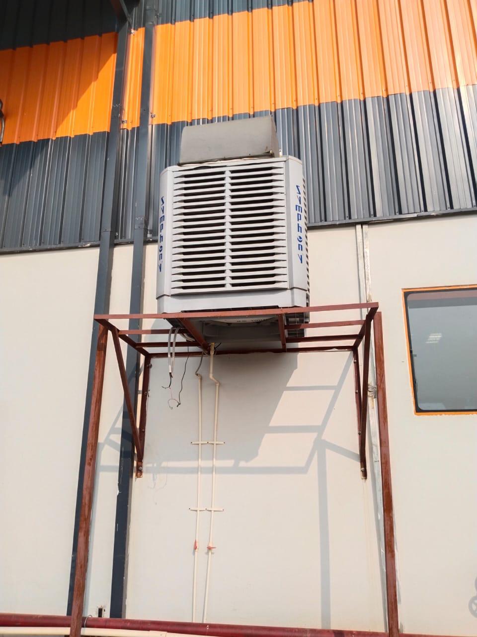 Symphony air cooler on a fabricated steel bracket outside a factory building.