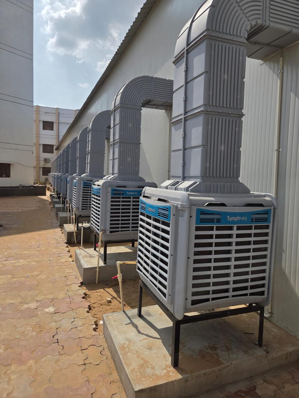 Row of ducted Symphony industrial air coolers installed outside a warehouse
