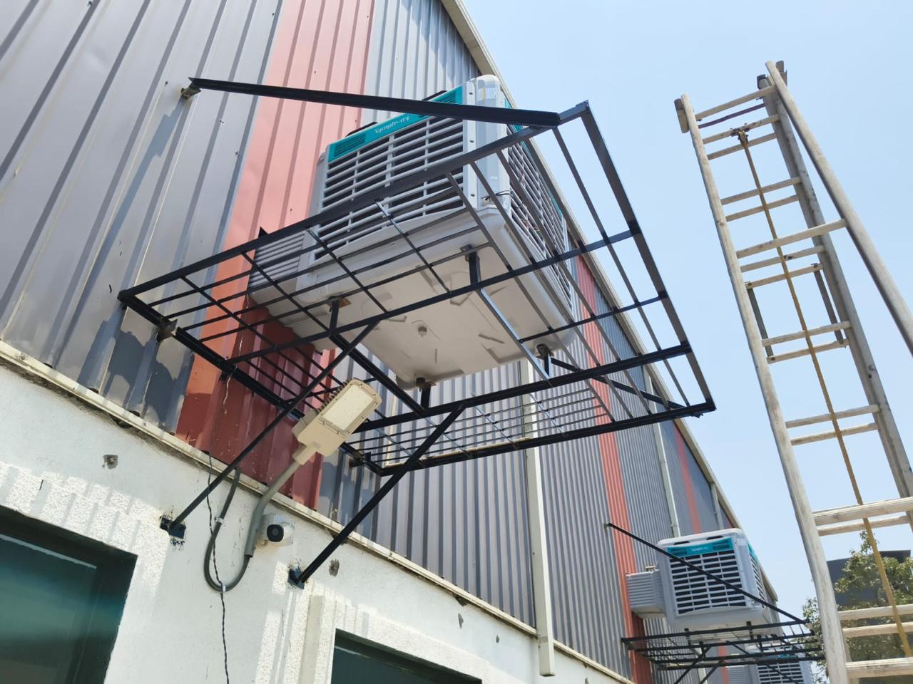 Industrial air cooler on a fabricated wall bracket for an industrial shed.